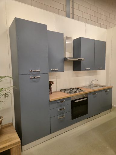 Moderne keuken met grijze kasten en een houten aanrechtblad.