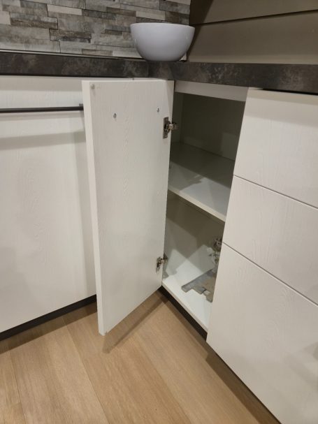 Strakke eenvoud, maximaal wooncomfort Open keukenkast met een lege schap en een witte kom bovenop.