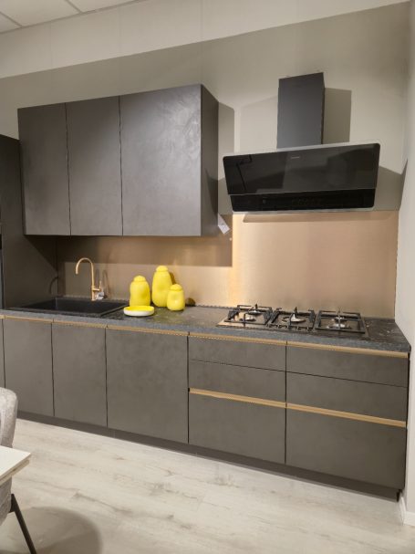 Moderne antracietgrijze keuken Moderne keuken met een grijs kleurenschema en zwarte afzuigkap. Gele decoratieve items.