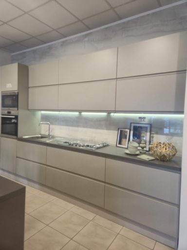 Moderne keuken met strakke kasten, aanrecht en ingebouwde verlichting.