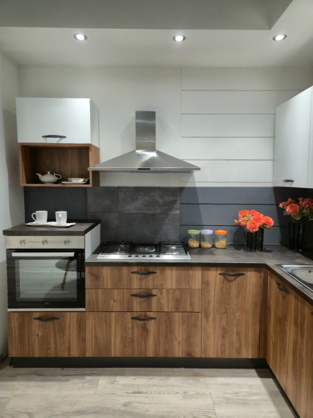 Warme uitstraling, slim ontworpen Moderne keuken met houten kasten, gasfornuis en bloemen in een vaas.