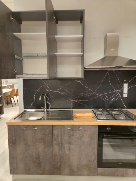 Moderne keuken met houten werkblad, zwarte wand en inbouwapparatuur.