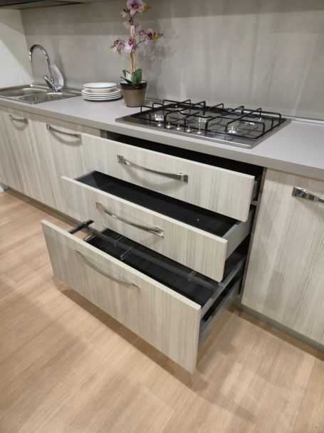 Tijdloze elegantie met Italiaans design Moderne keuken met open lades en een gasfornuis op een houten vloer.