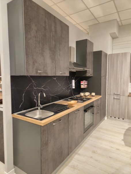 Moderne keuken in grijstinten met houten werkblad en inbouwapparatuur.