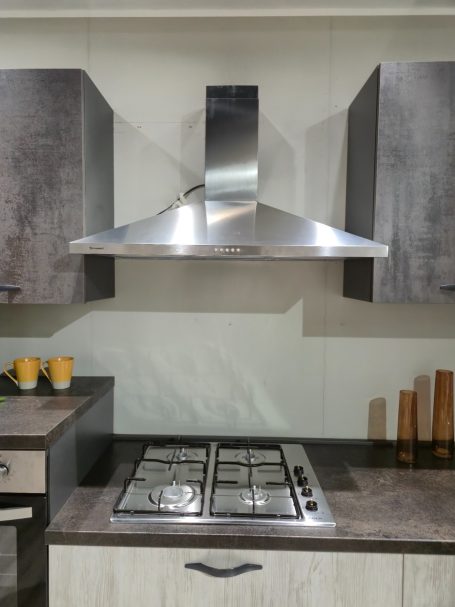 Moderne keuken met een roestvrijstalen afzuigkap en een gaskookplaat.
