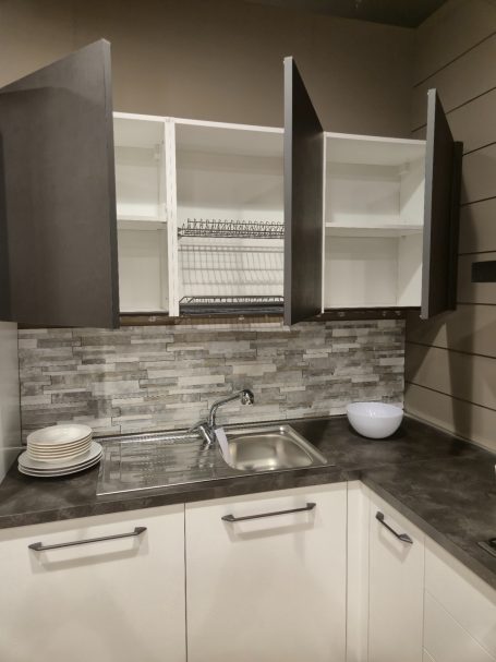Strakke eenvoud, maximaal wooncomfort Moderne keuken met open bovenkasten, spoelbak en stenen werkblad.
