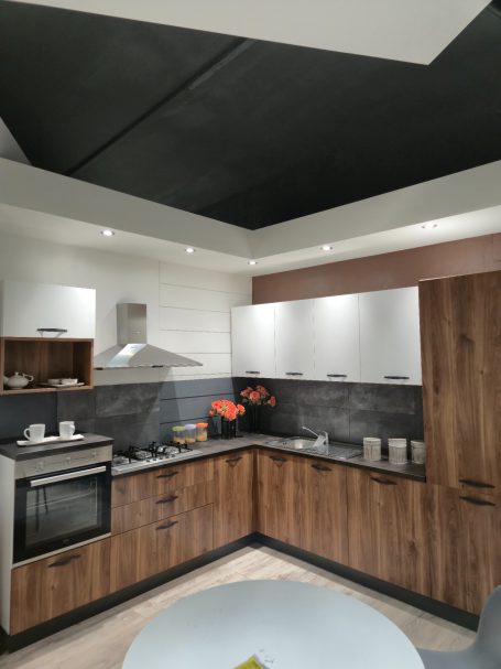 Warme uitstraling, slim ontworpen Moderne keuken met houten kasten, grijze wanden en een kookplaat.