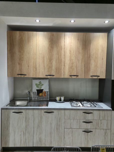 Moderne keuken met houten kasten, gasfornuis en een minimalistische uitstraling.