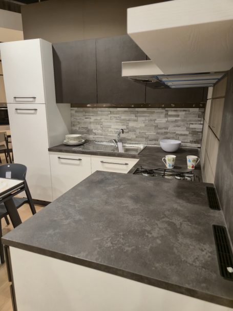 Strakke eenvoud, maximaal wooncomfort Moderne keuken met grijze werkbladen, gaskookplaat en lichte kastjes.