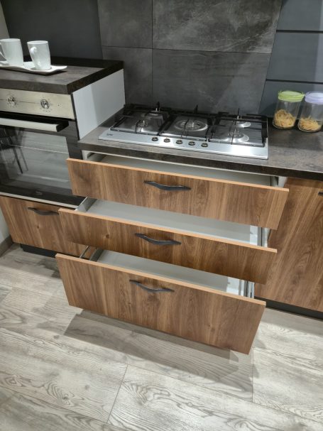 Warme uitstraling, slim ontworpen Moderne keuken met houten laden en een gasfornuis.