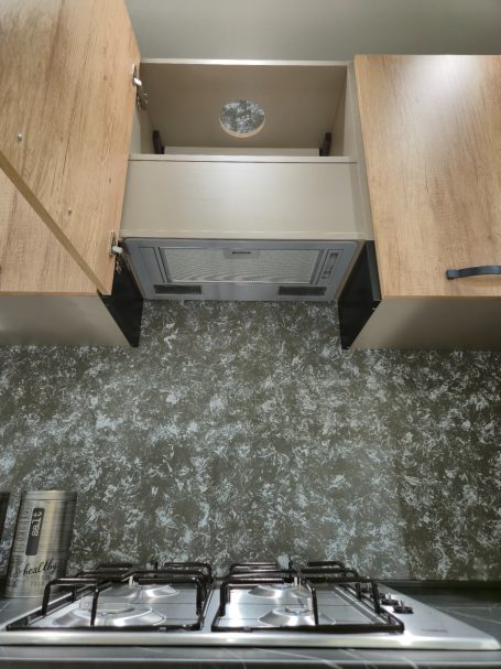 Modern design met een stijlvolle twist Moderne keuken met houten kasten, een afzuigkap en een gasfornuis.