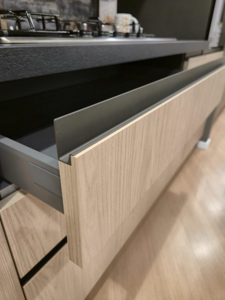 Pure luxe in perfect design Houten lade van een modern keukenkastje, half open met een grijze binnenzijde.