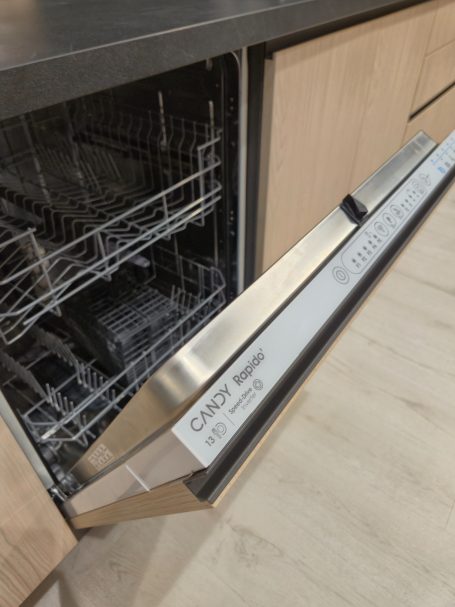 Pure luxe in perfect design Open vaatwasmachine met metalen handgreep en lege rekken.