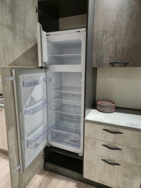 Lege koelkast met open deur, in een moderne keukenomgeving.