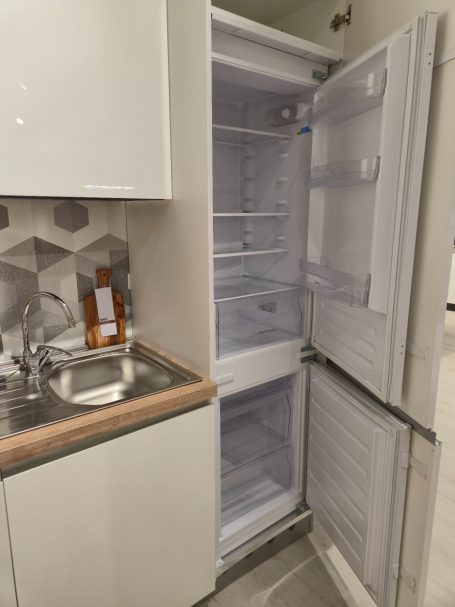 Pure elegantie in Italiaans design Leeg koelkast met een kleine vriezer en een wasbak in de keuken.