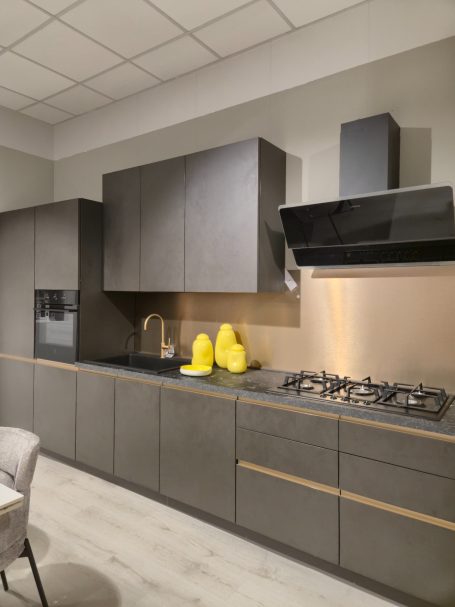 Moderne antracietgrijze keuken Moderne keuken met donkere kasten, een kookplaat en gele decoratieve items.