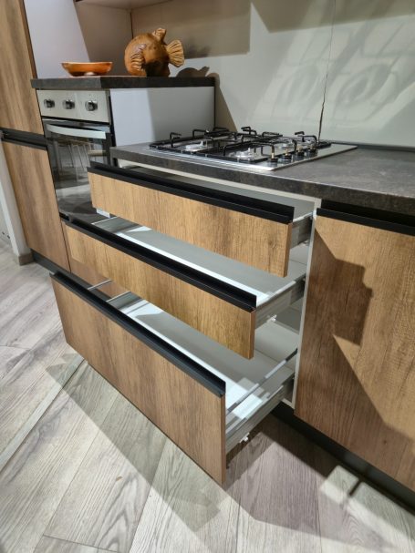 Natuurlijke warmte in modern design Laden van een moderne keukenkast met houten afwerking, open met metalen rails.