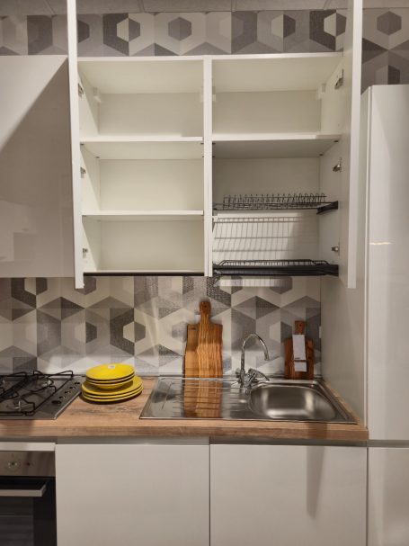 Pure elegantie in Italiaans design Een moderne keuken met een houten aanrecht, open kast en geometrisch behang.