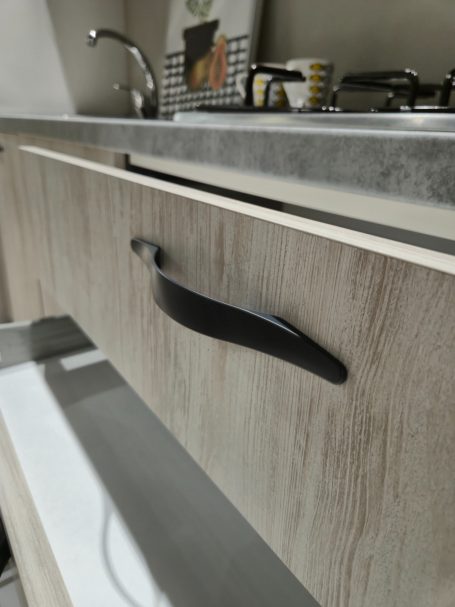 Lade met een zwarte handgreep, plat ontwerp, in een moderne keukenomgeving.