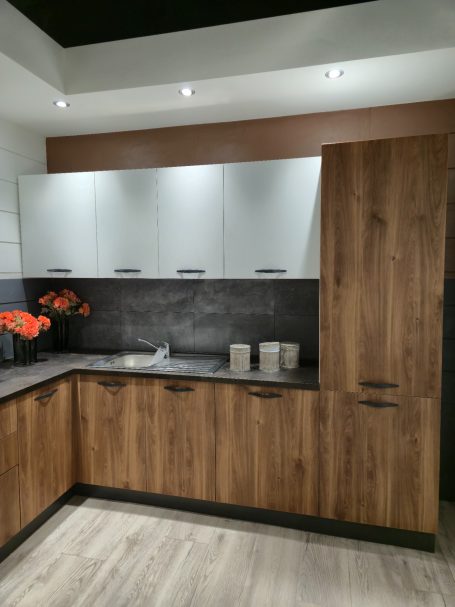Warme uitstraling, slim ontworpen Moderne keuken met houten kasten, een werkblad en oranje bloemen als decoratie.