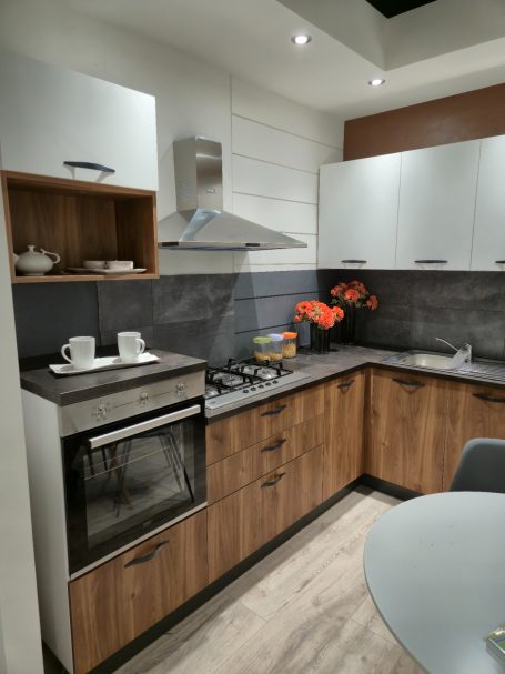 Warme uitstraling, slim ontworpen Moderne keuken met houtaccenten, kookplaat, oven en bloemen als decoratie.