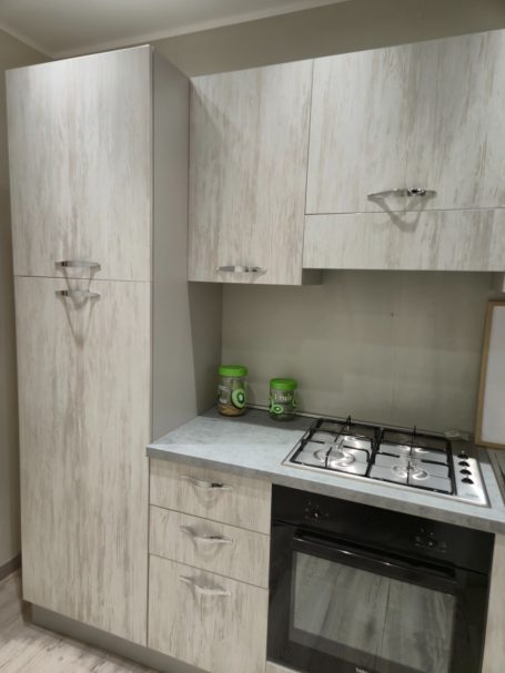 Moderne keuken met lichte, houtachtige kasten en een gasfornuis.