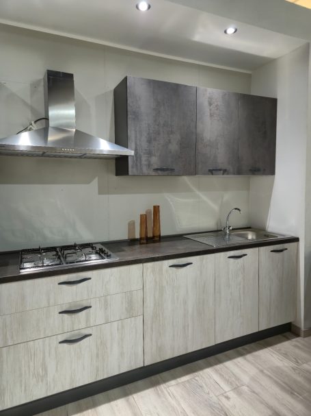 Moderne keuken met een betonlook afzuigkap en houten keukenkastjes.