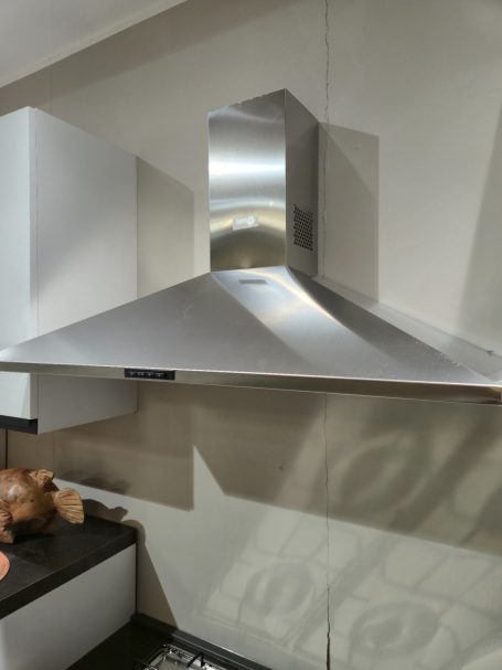 Natuurlijke warmte in modern design RVS afzuigkap met een brede, schuine rand boven een keukenwerkblad.