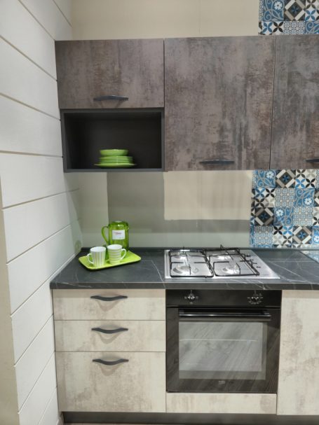 Mira keuken – Moderne rechte keuken met houtlook Moderne keuken met houten kasten, gasfornuis en groene serviesstukken.
