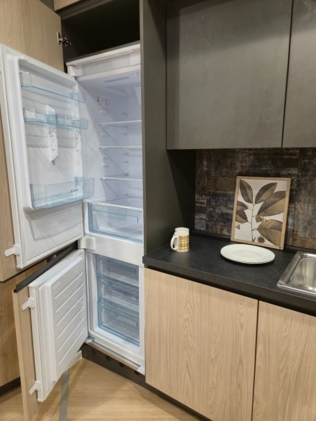 Pure luxe in perfect design Open koelkast met een witte binnenzijde en een dicht aanrecht in een moderne keuken.