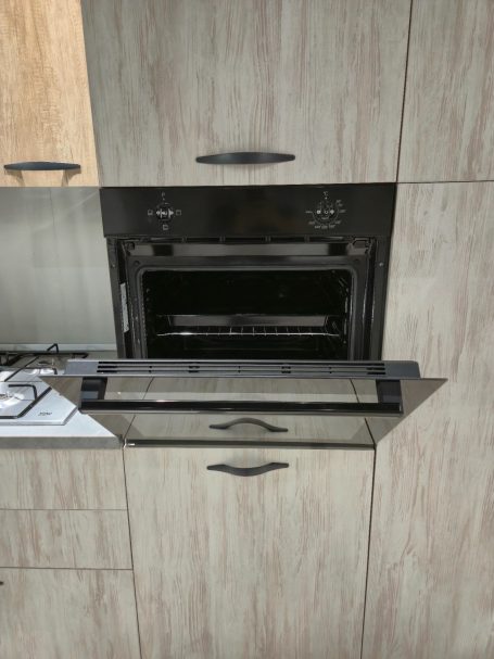 Ingebouwde oven met open deur in een moderne keuken.