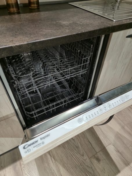 Een open vaatwasser met een metalen interieur en een moderne uitstraling.