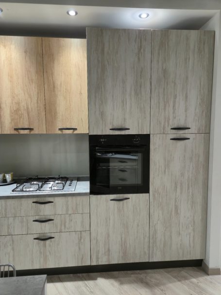 Moderne keuken met houten kasten en een zwarte inbouwoven.