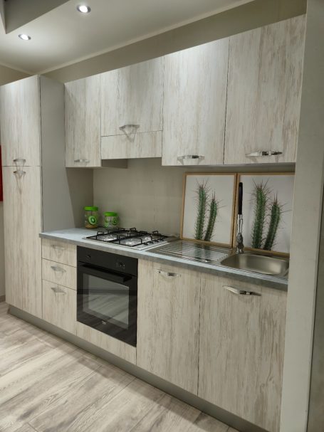 Moderne keuken met houten kasten, een fornuis en decoratieve planten.