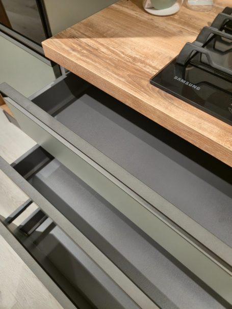 Moderne matgroene keuken Lade van een moderne keuken met een houten bovenblad en een gaskookplaat.