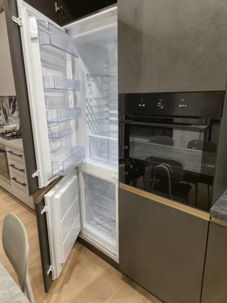 Moderne antracietgrijze keuken Moderne koelkast met een open deur en een geïntegreerde oven ernaast.