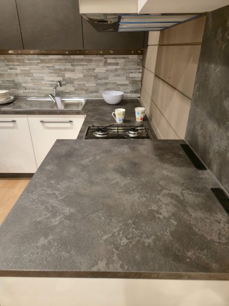Strakke eenvoud, maximaal wooncomfort Moderne keuken met een stenen aanrechtblad en een gootsteen in de achterwand.
