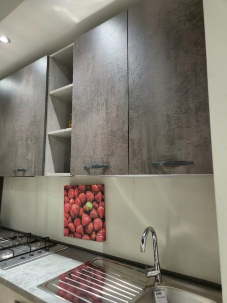 Moderne keuken met houten kastjes en een wanddecoratie van aardbeien.